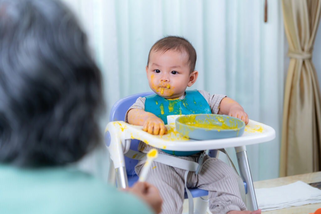 a little child eating his first meal on a high cha 2025 01 10 02 22 13 utc